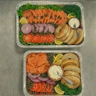 Lox platter catering trays with bagels, smoked salmon, cream cheese, tomatoes, onions, capers, and lettuce at Ally’s Comfort Café in Davie, FL